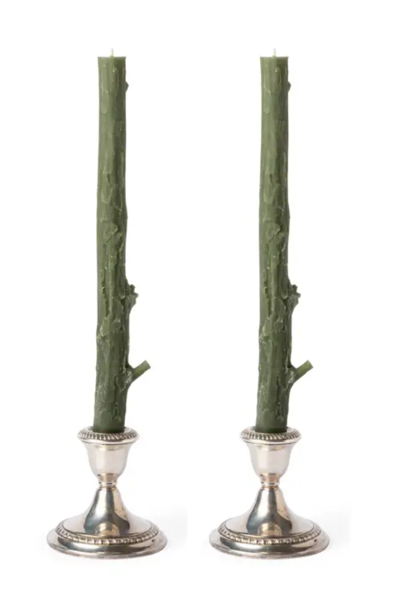 Two green branch candles in silver candle holders on a white background