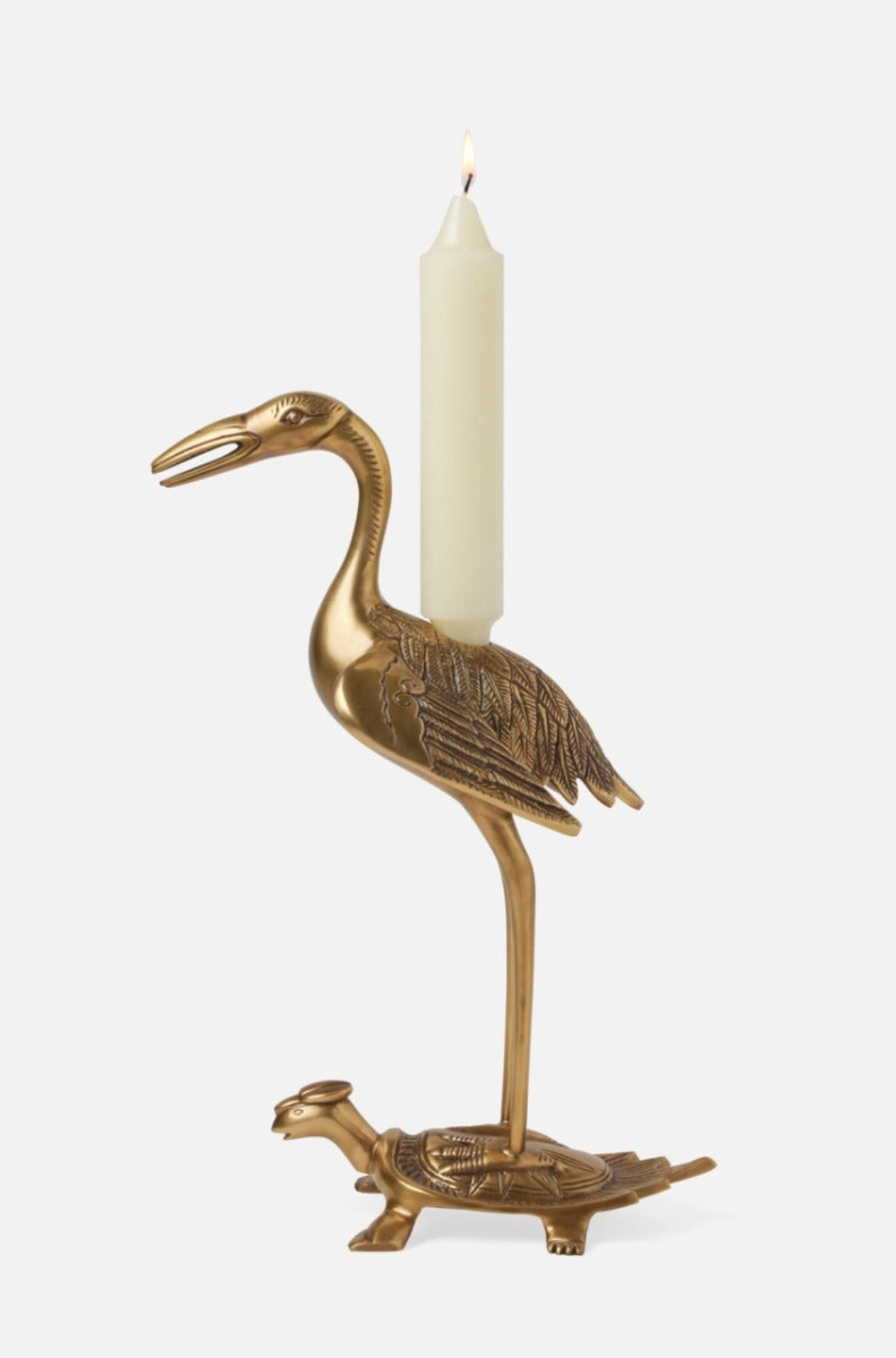 Brass bird-shaped candle holder with a white candle on a white background