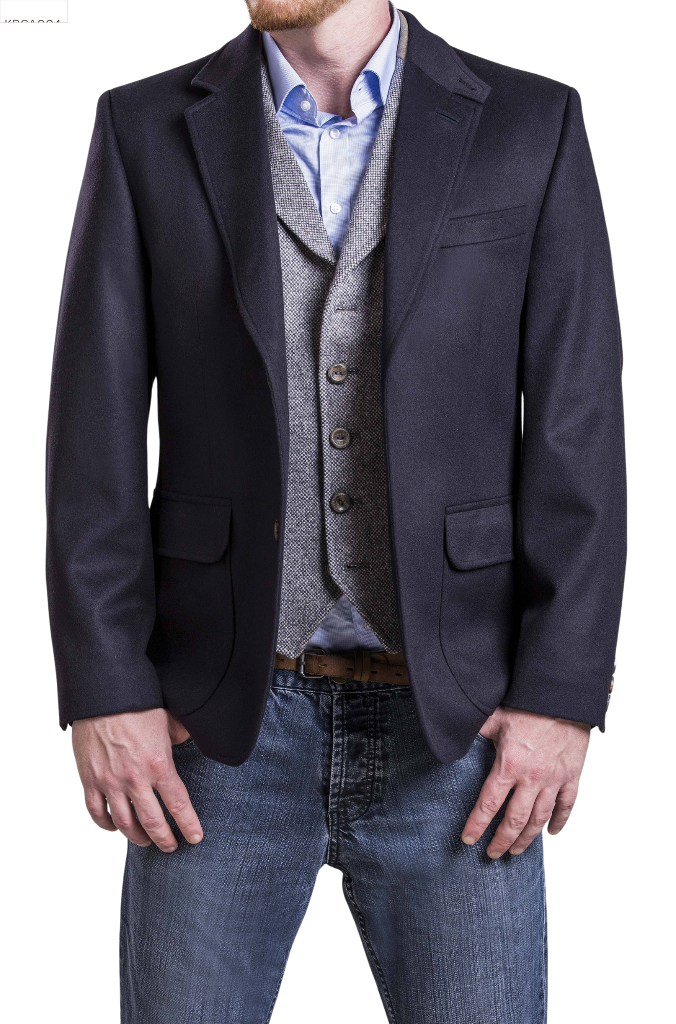 Man wearing a dark blazer, light blue shirt, gray vest, and jeans on a white background