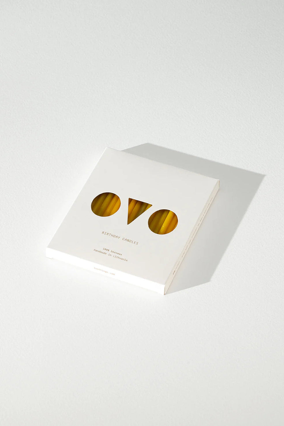 White box of beeswax candles with gold 'ovo' logo on a white background