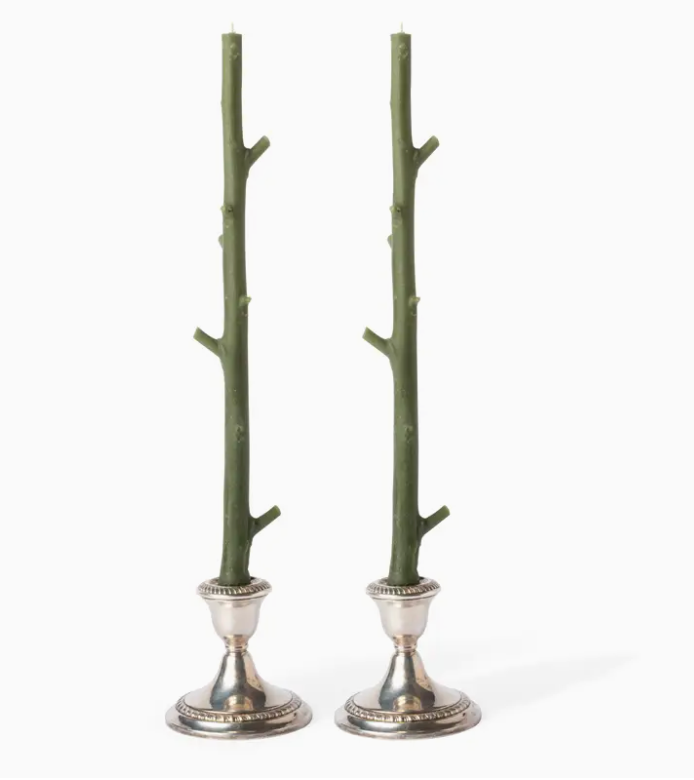 Two green branch-like candle holders with silver bases on a white background