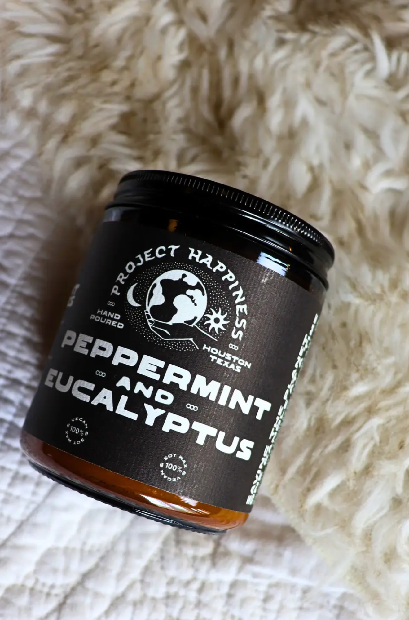 Project Happiness peppermint and eucalyptus jar candle on a textured surface